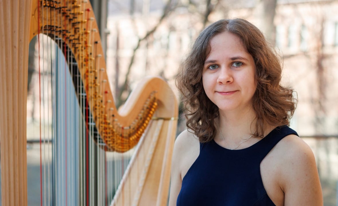 Audrey Morris stands next to her harp.