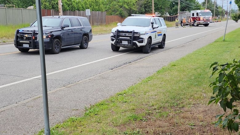 Police cars and a fire truck are seen on a Prince George road. 
