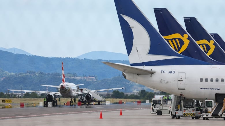 Planes are seen parked on a tarmac.