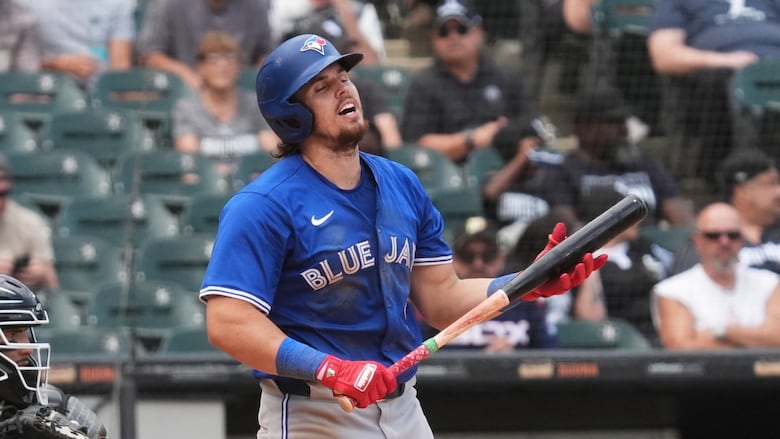 A men's baseball player reacts after striking out.