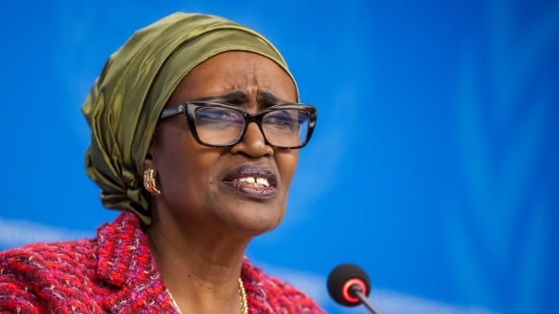 A woman speaks behind a microphone.