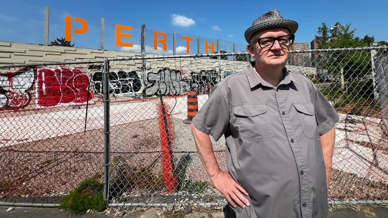 A man stands in front of a construction zone the Perth Avenue railpath corridor. 
