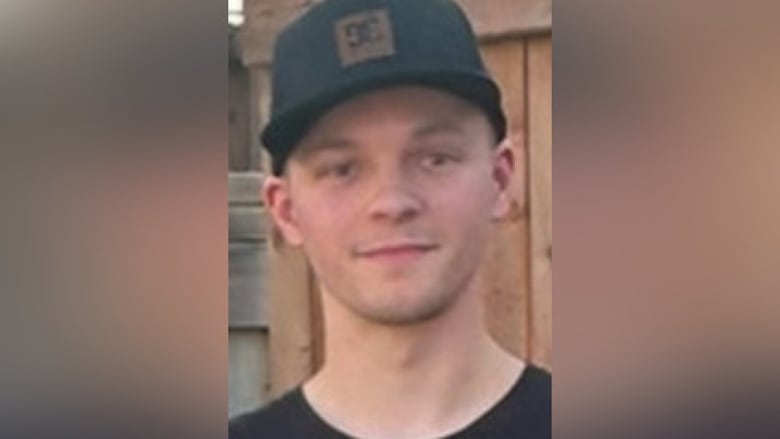 A man with a black hat poses for a picture