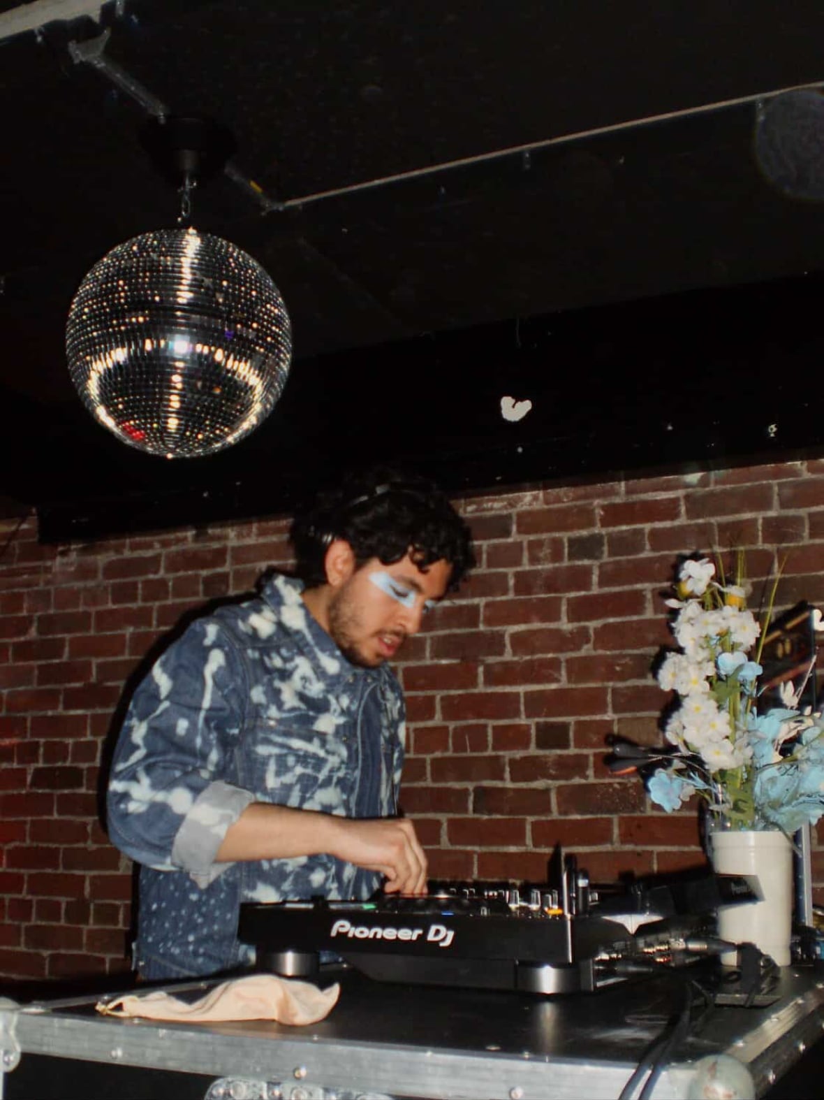 A man in blue with eye shadow, DJs.