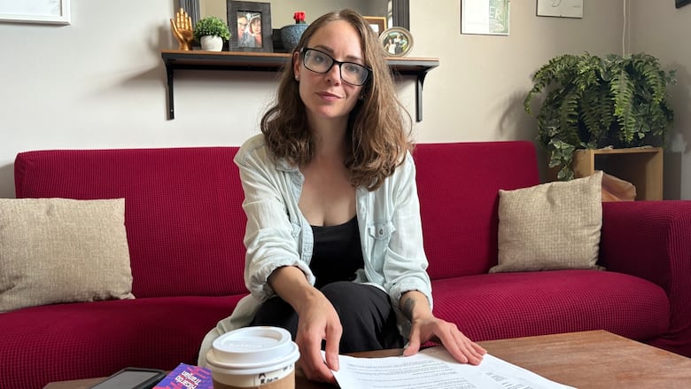 A pistillate   sits astatine  a array  with papers successful  beforehand   of her