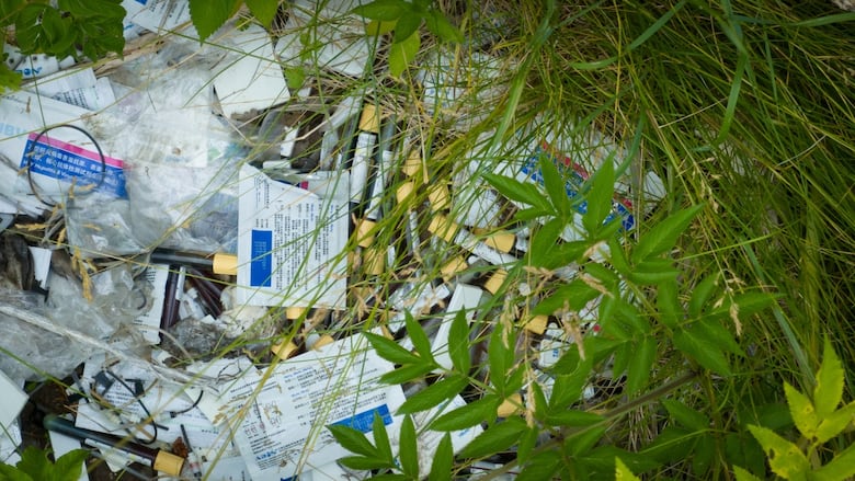 Medical waste near abandoned buildings on a private property.