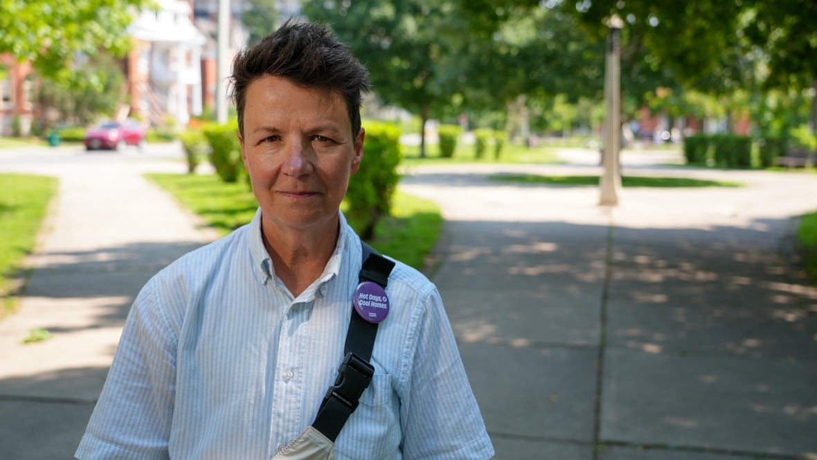 A person with a blue shirt stands in a park.