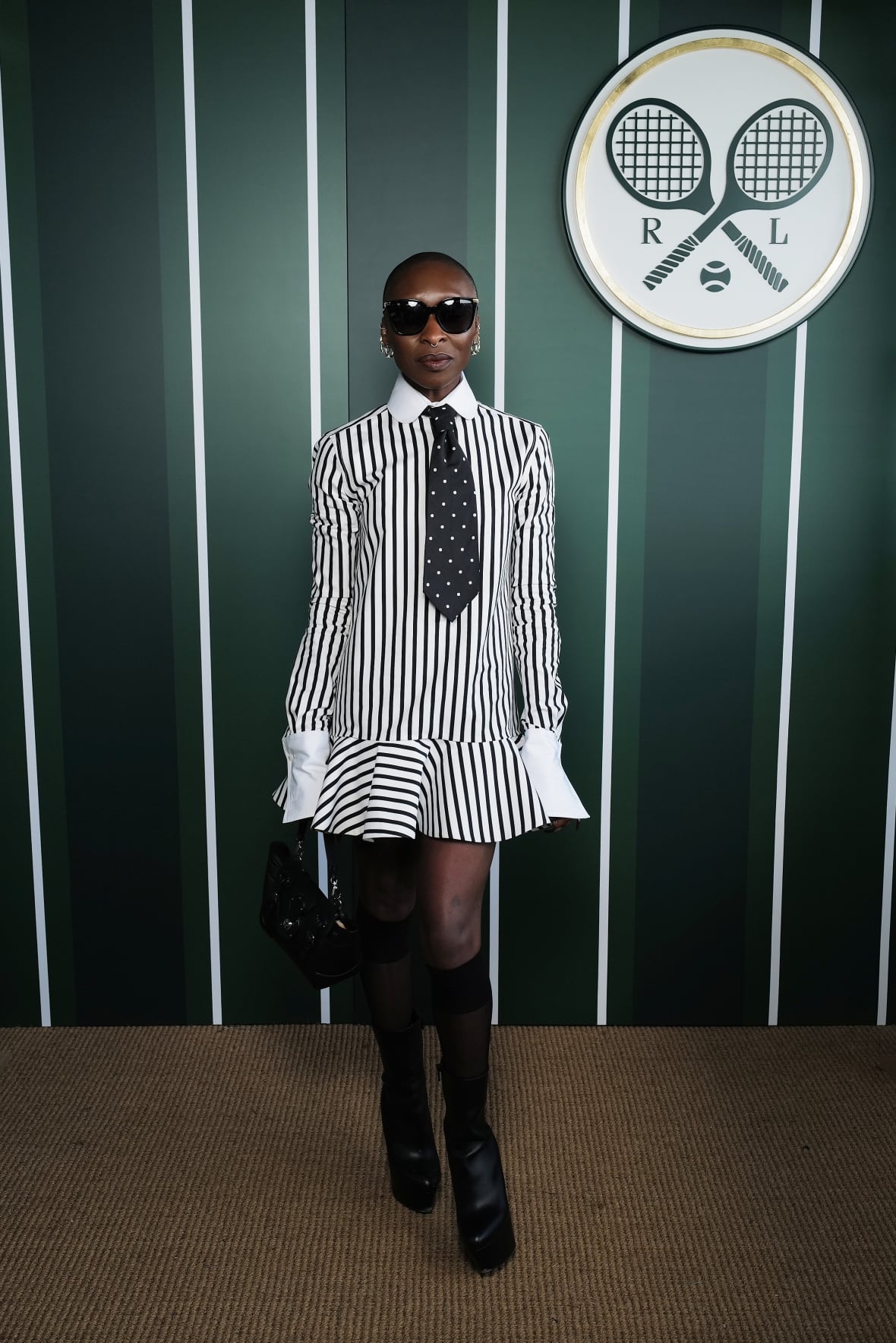 A woman poses for a photo wearing a striped shirtdress.