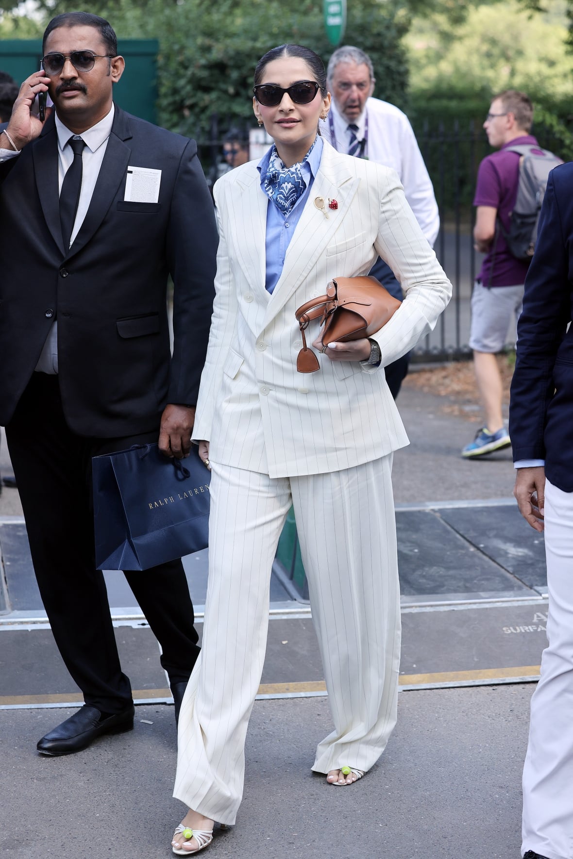 A woman wearing a white suit poses for a photo.