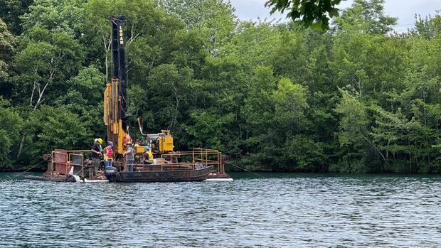 Floating barge on Chocolate Lake scoping out conditions for updated dam