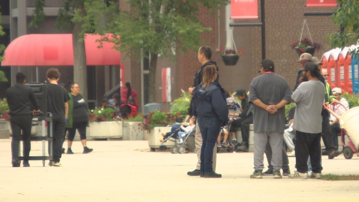 Evacuees, security and other support workers can be seen outside a university facility being used as an emergency sheltter.
