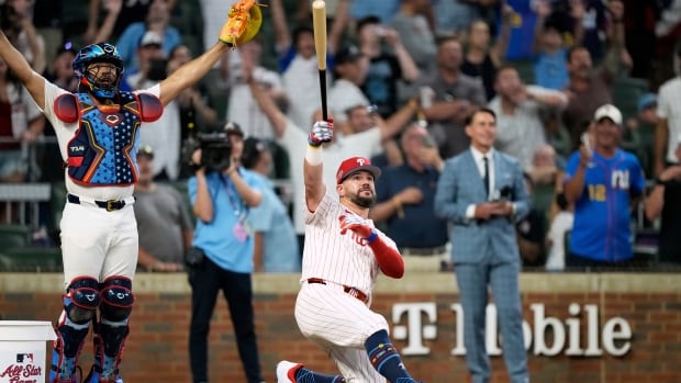 A man on one knee lifts a bat in the air.