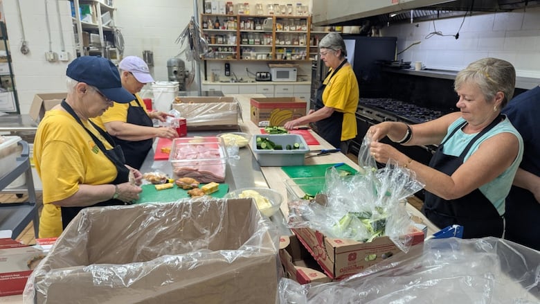 People working in a school kitchen.