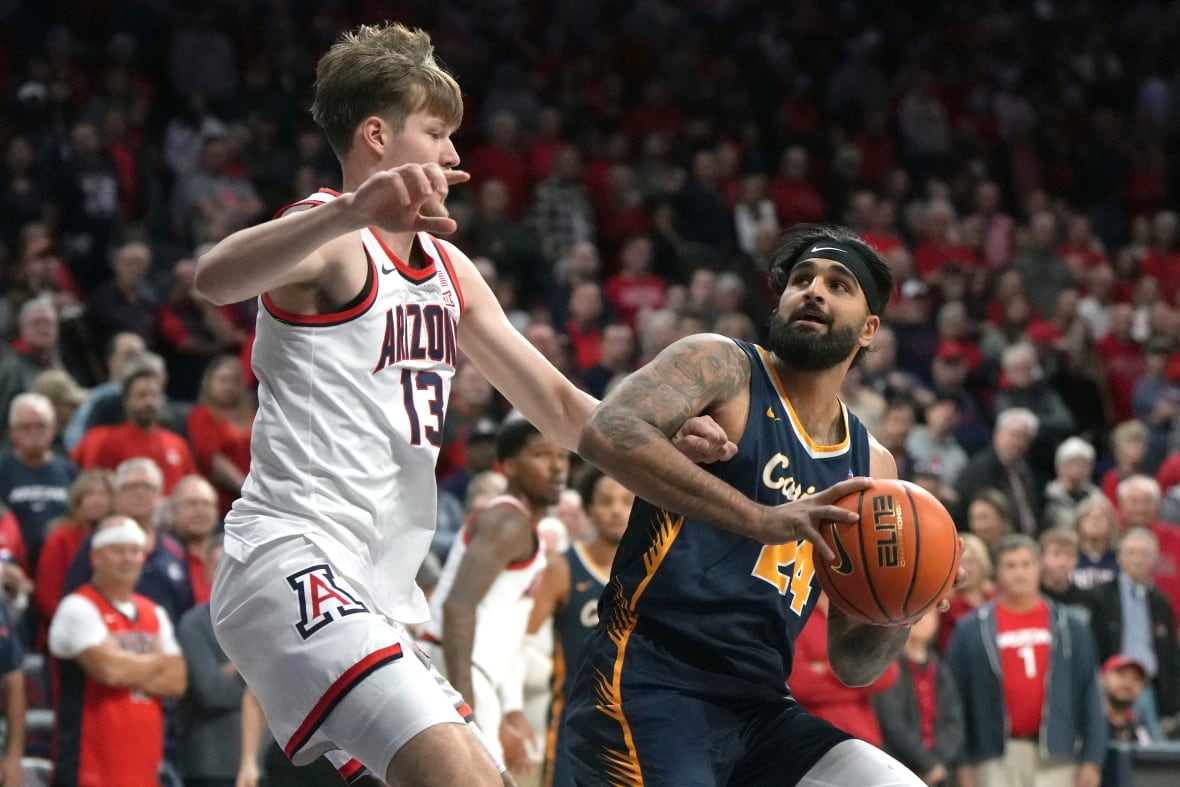 Two basketball players battle for the ball.