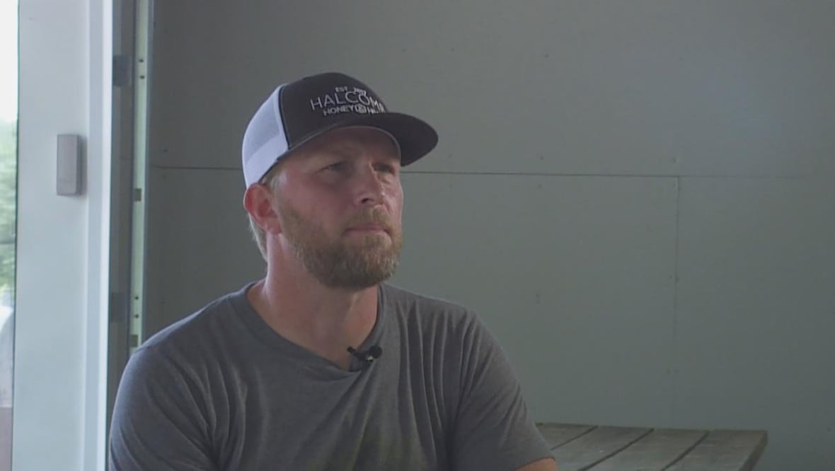 Close up of man sitting on a picnic table.