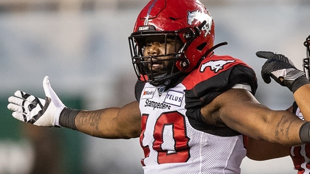 Calgary Stampeders defensive lineman Shawn Lemon celebrates his tackle on Edmonton Elks quarterback Trevor Harris with Andrew Seinet-Spaulding during a September 11, 2021 CFL regular-season game in Edmonton, Alberta.
