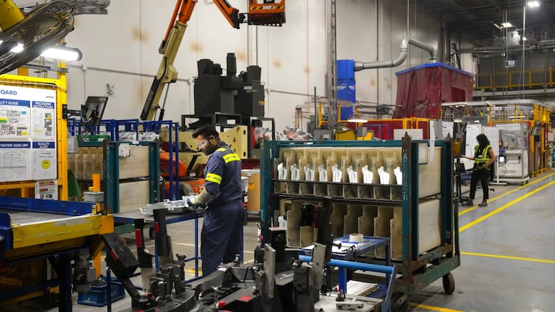A worker on the assembly line of an auto parts manufacturing plant.