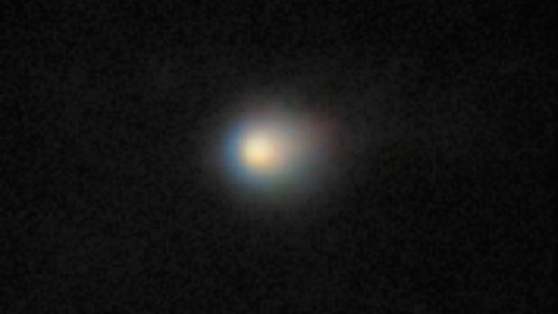 Comet 3I/ATLAS is captured in this image by the Gemini North telescope. The incredible sensitivity of Gemini North's Multi-Object Spectrograph (GMOS-N) reveals the comet’s compact coma — a cloud of gas and dust surrounding its icy nucleus A yellowish fuzzy object sits in a black sky.