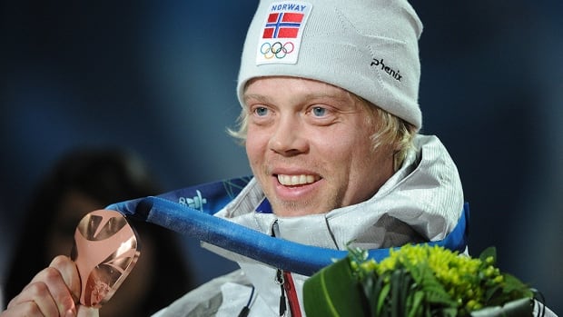 Norwegian ski cross racer Audun Groenvold holds a bronze medal in his right hand during the medal ceremony of the men's final of the Vancouver Winter Olympics on February 21, 2010.