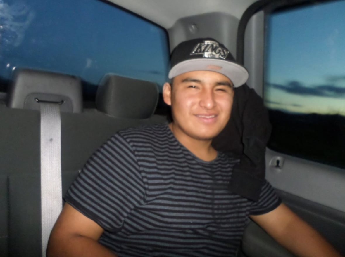 A young man sitting in a car.