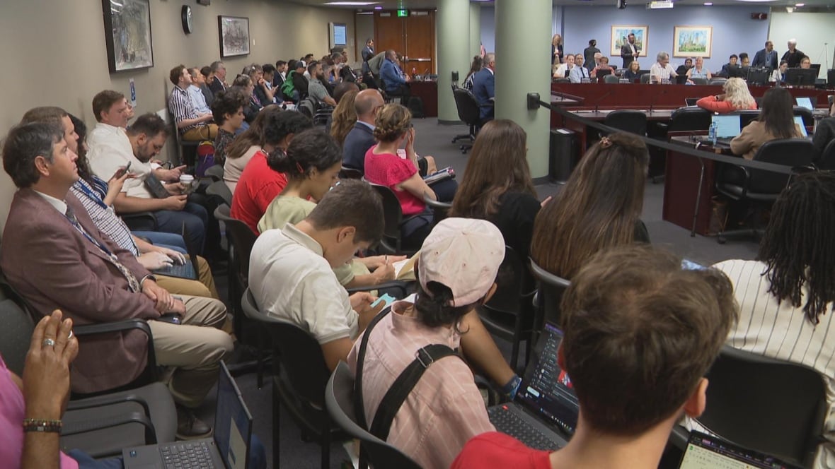 Many people sitting in guest area of city council
