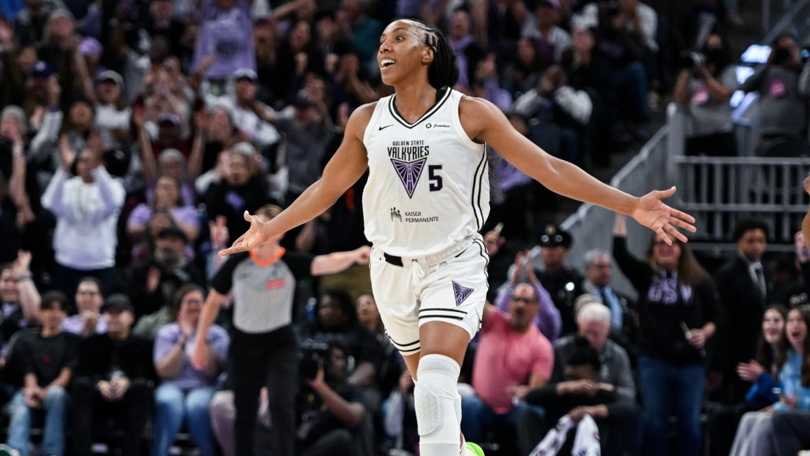 A women's basketball player reacts in celebration during a game.