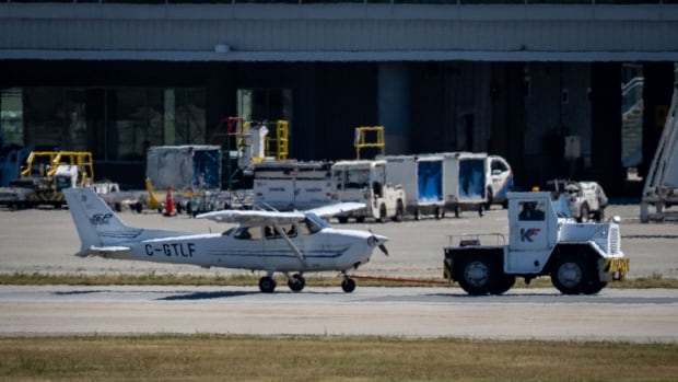 A small plane is seen with a truck in front of it.