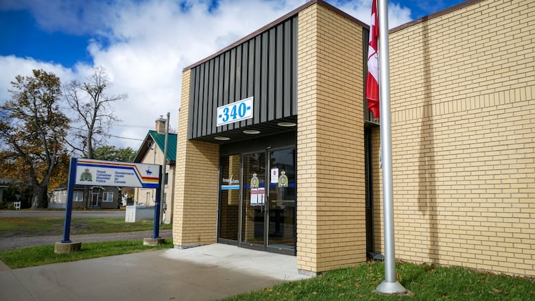 The exterior of a brick building with a sign reading "Royal Canadian Mounted Police" outside.