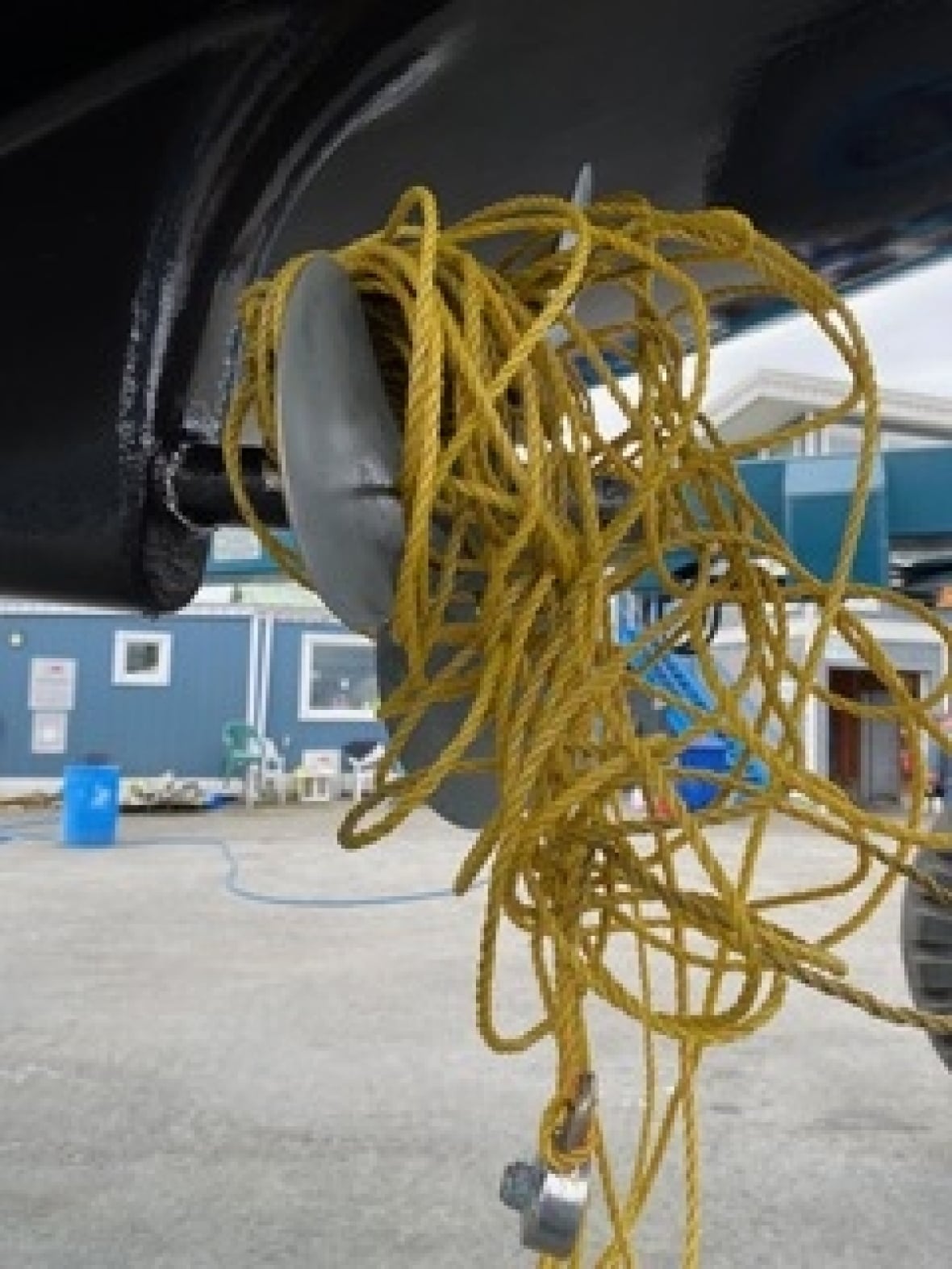 Tangle of yellow rope wrapped around the propeller of a boat