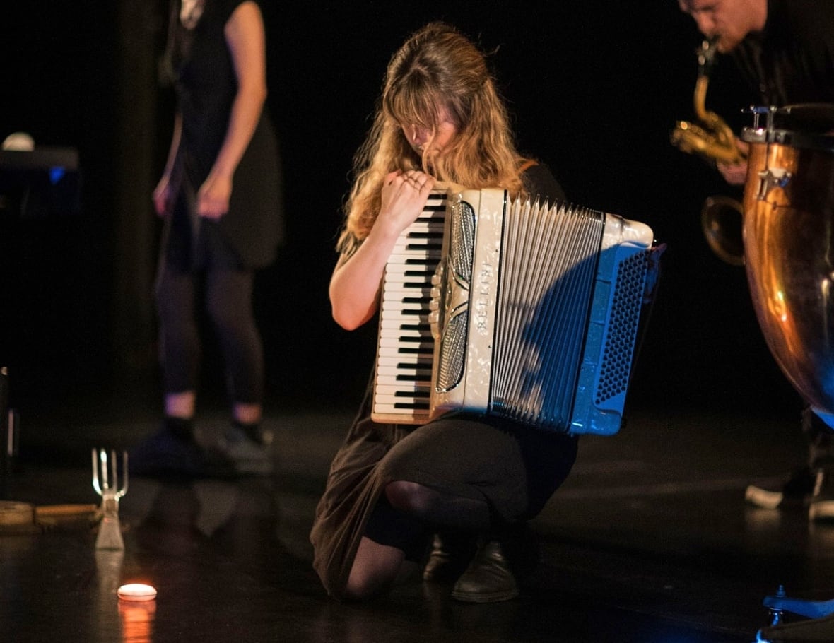 A woman playing an accordian.