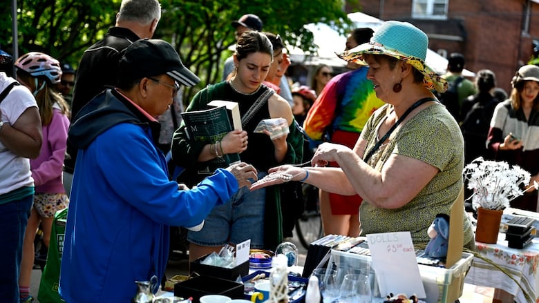 People mingle at a garage sale outdoors