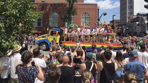 A crowd of people line the streets to watch the Pride Parade in downtown Halifax.