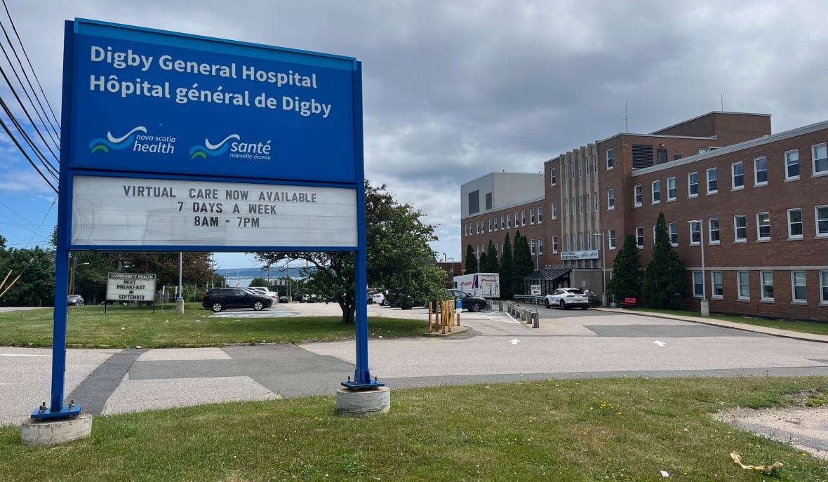 A hospital with a sign out front.
