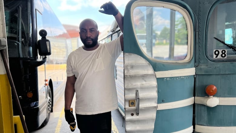 Robert Louis Brandon Edwards stands next to the Greyhound bus he's converting into a museum.