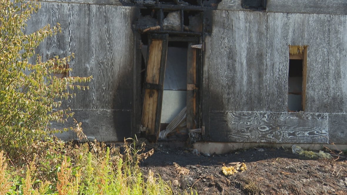 Building with door open. Fire damage to the building.