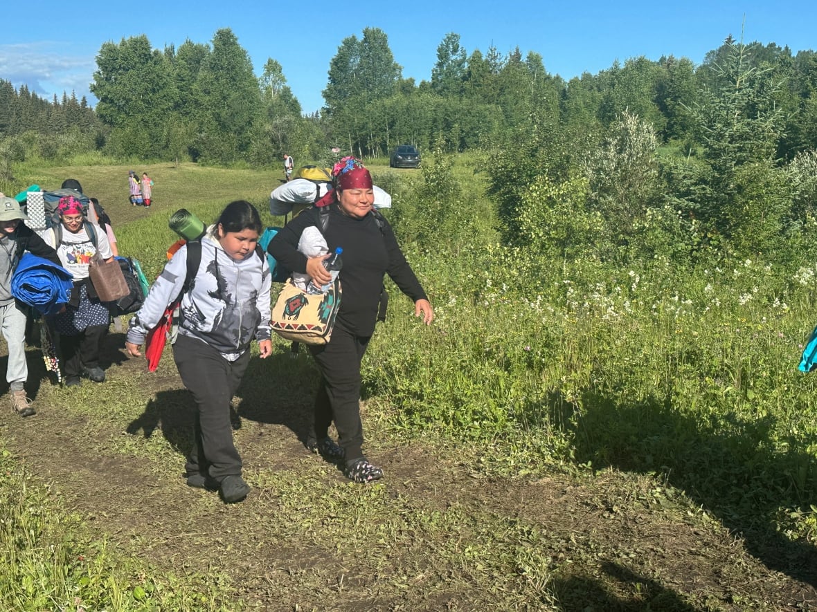 A group of people walking up a hill.