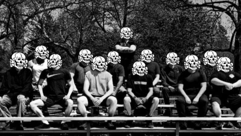 Black and white photo of people sitting in a posed group photo. Their faces are obscured by images of skulls typically used by neo-Nazis.