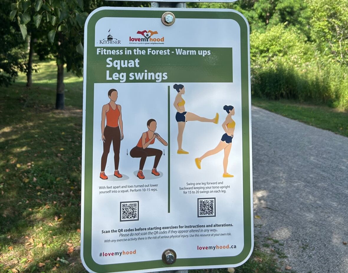 A sign encourages people to stretch and do leg squats. The sign is beside a walking trail in a park.