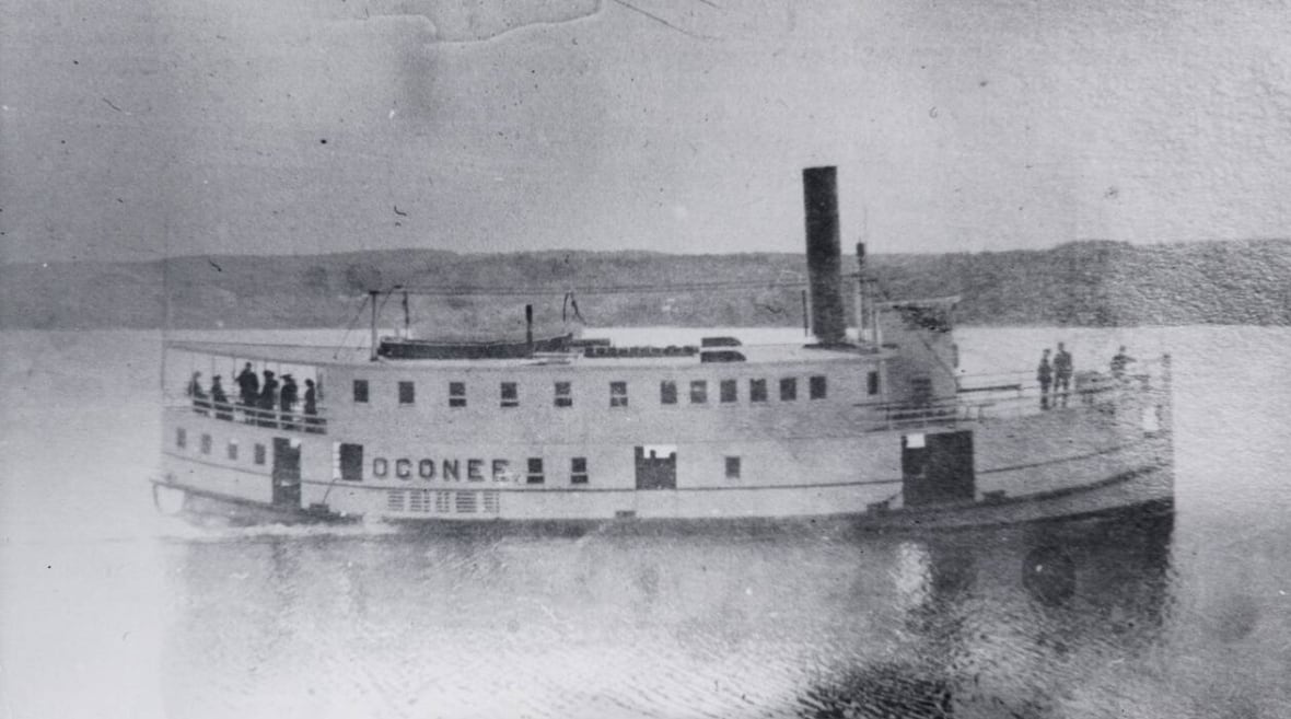 A black and white photo of a steamboat on a river.