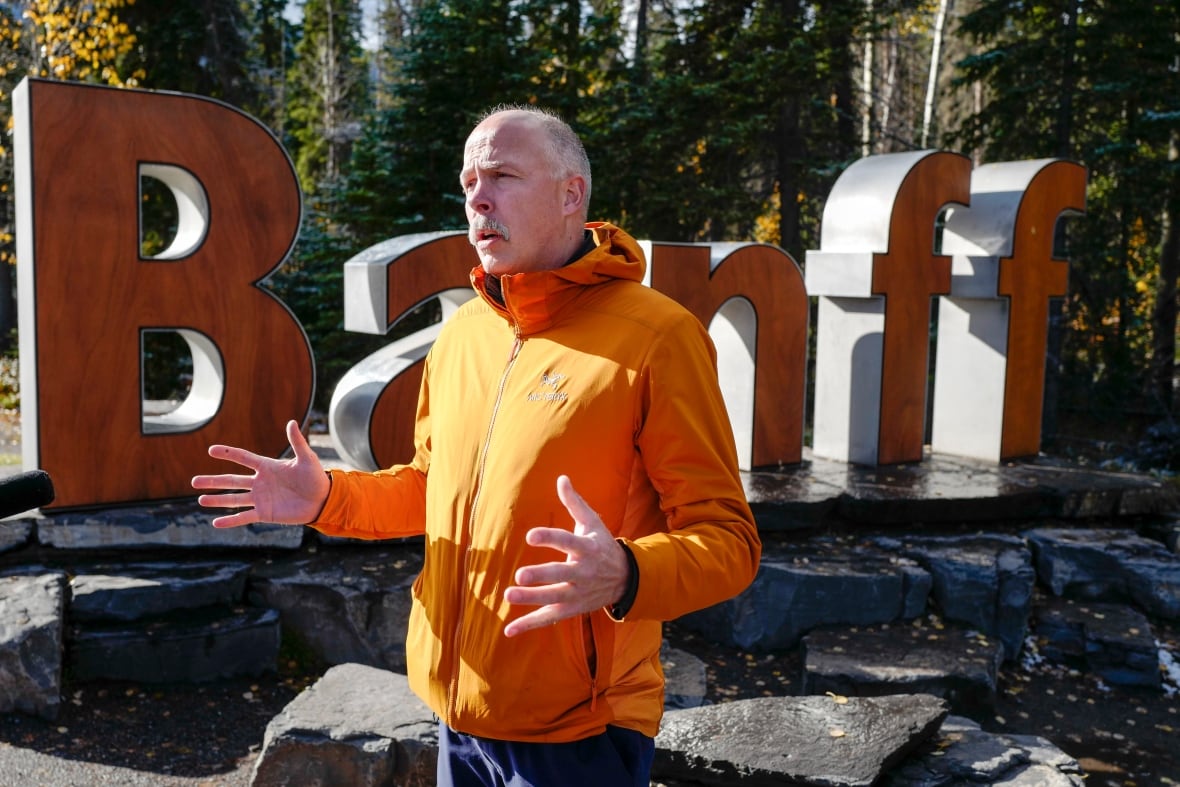 A man standing in front of a big sign.