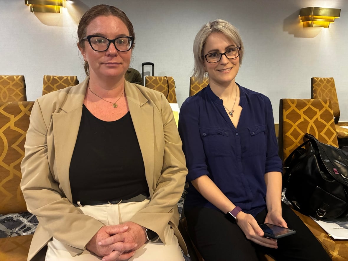 two women seated in a conference room
