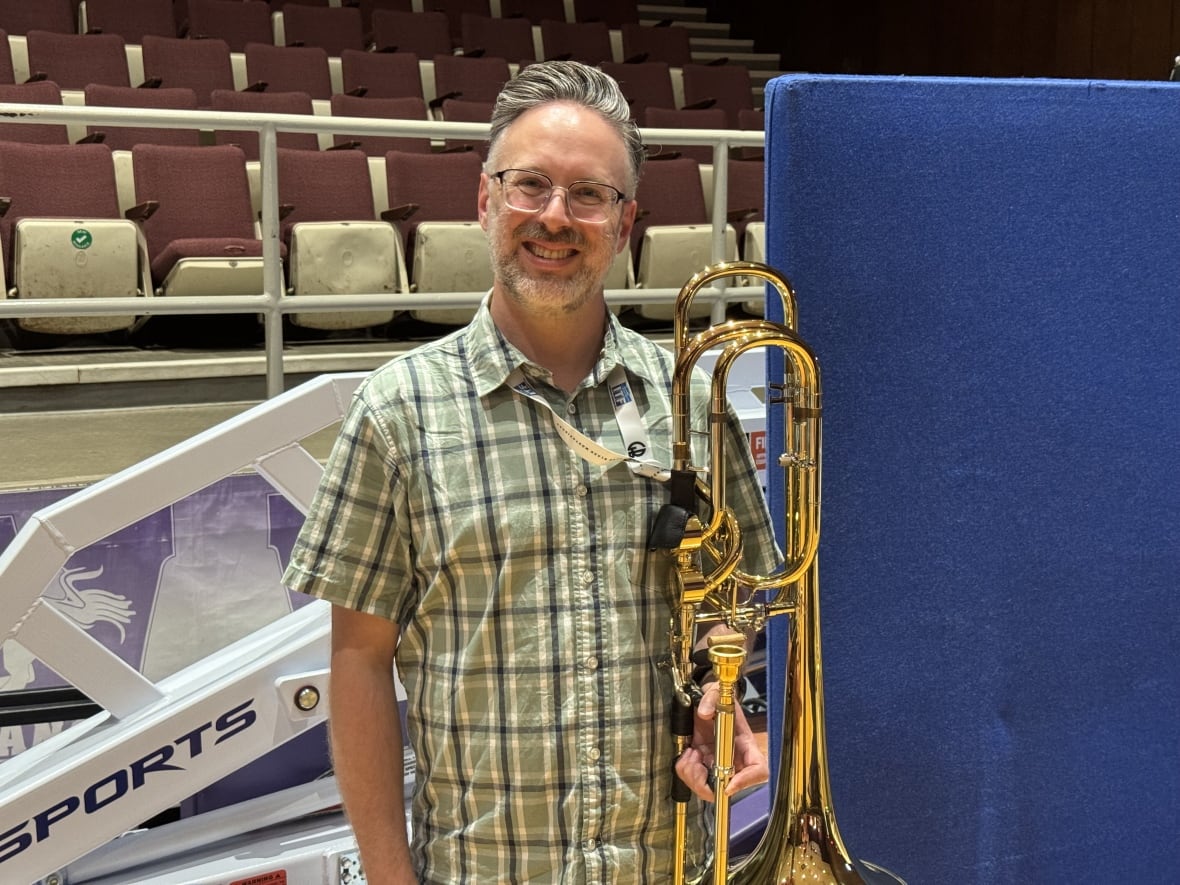 A man smiles with his trombone