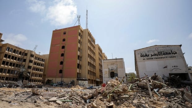 Destroyed university buildings. The name of a university is written in English and Arabic.