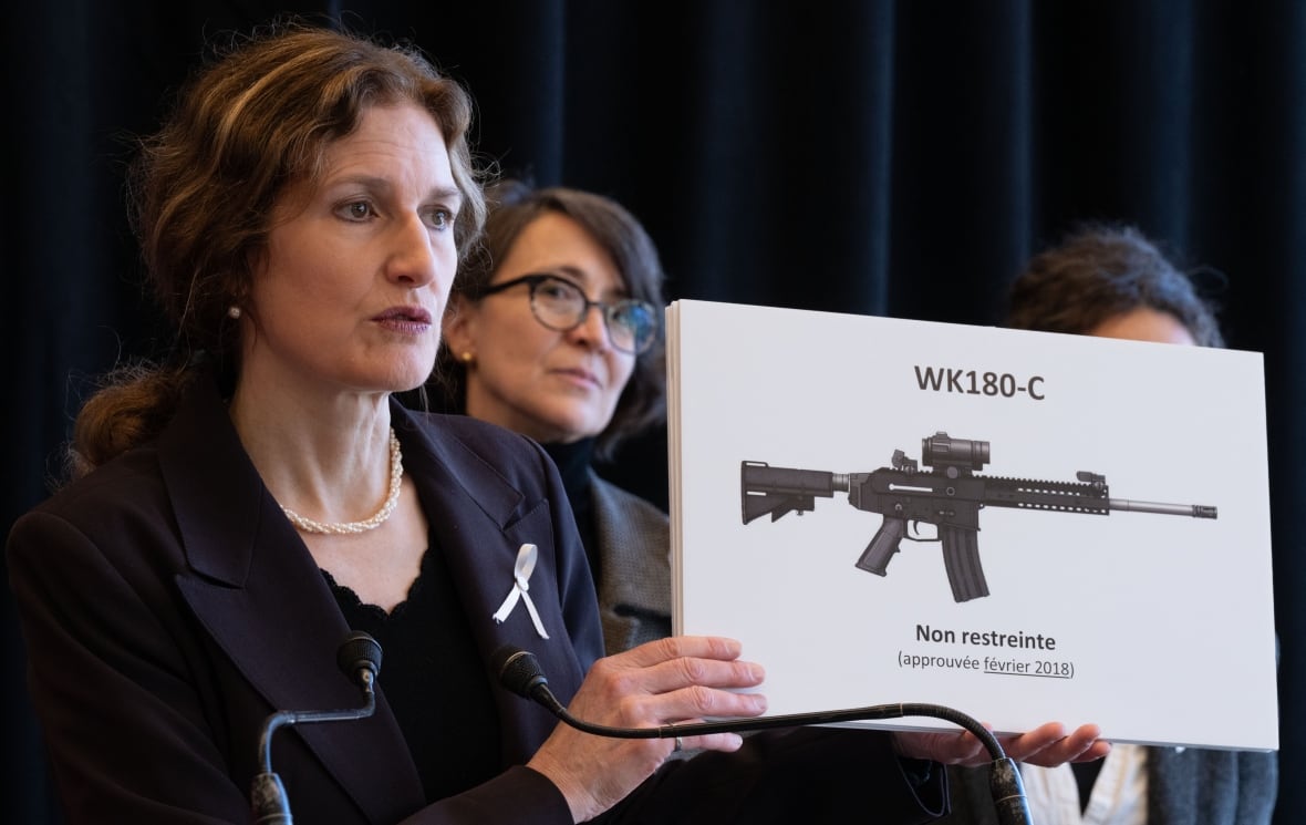 A woman holds up a gun on a sign.