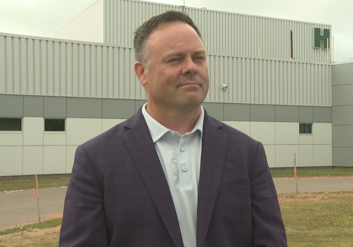 Man in suit standing in front of hospital building.