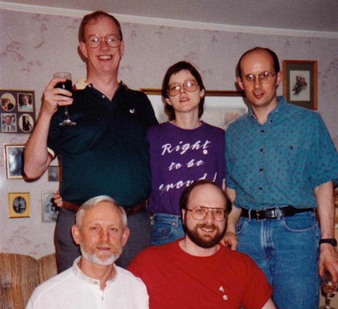 Five people sitting and standing for a photo.