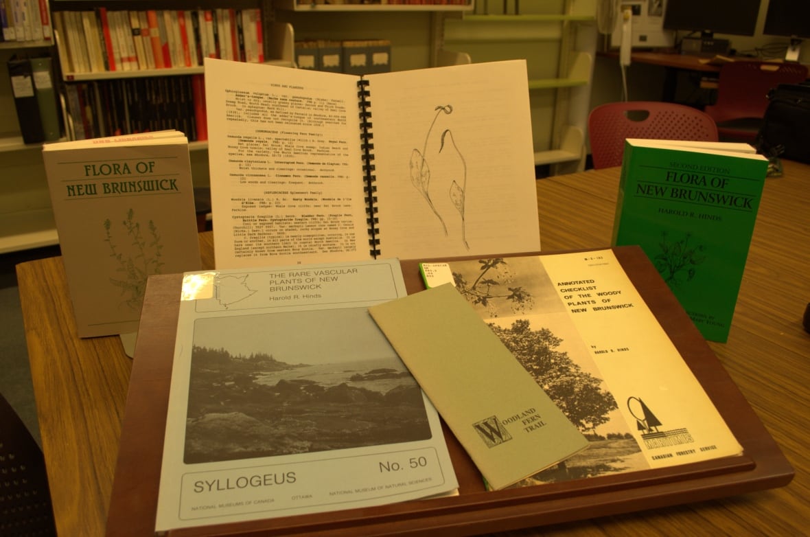 A collection of books on a wooden table.