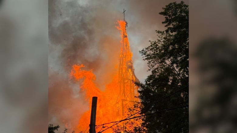 A photo shared by the municipality of Saint-Ours on Facebook shows flames tearing through the church's spire Thursday afternoon. 