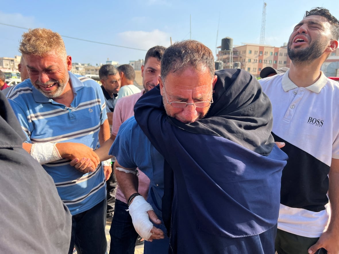 Relatives of victims killed in airstrikes comfort one another.