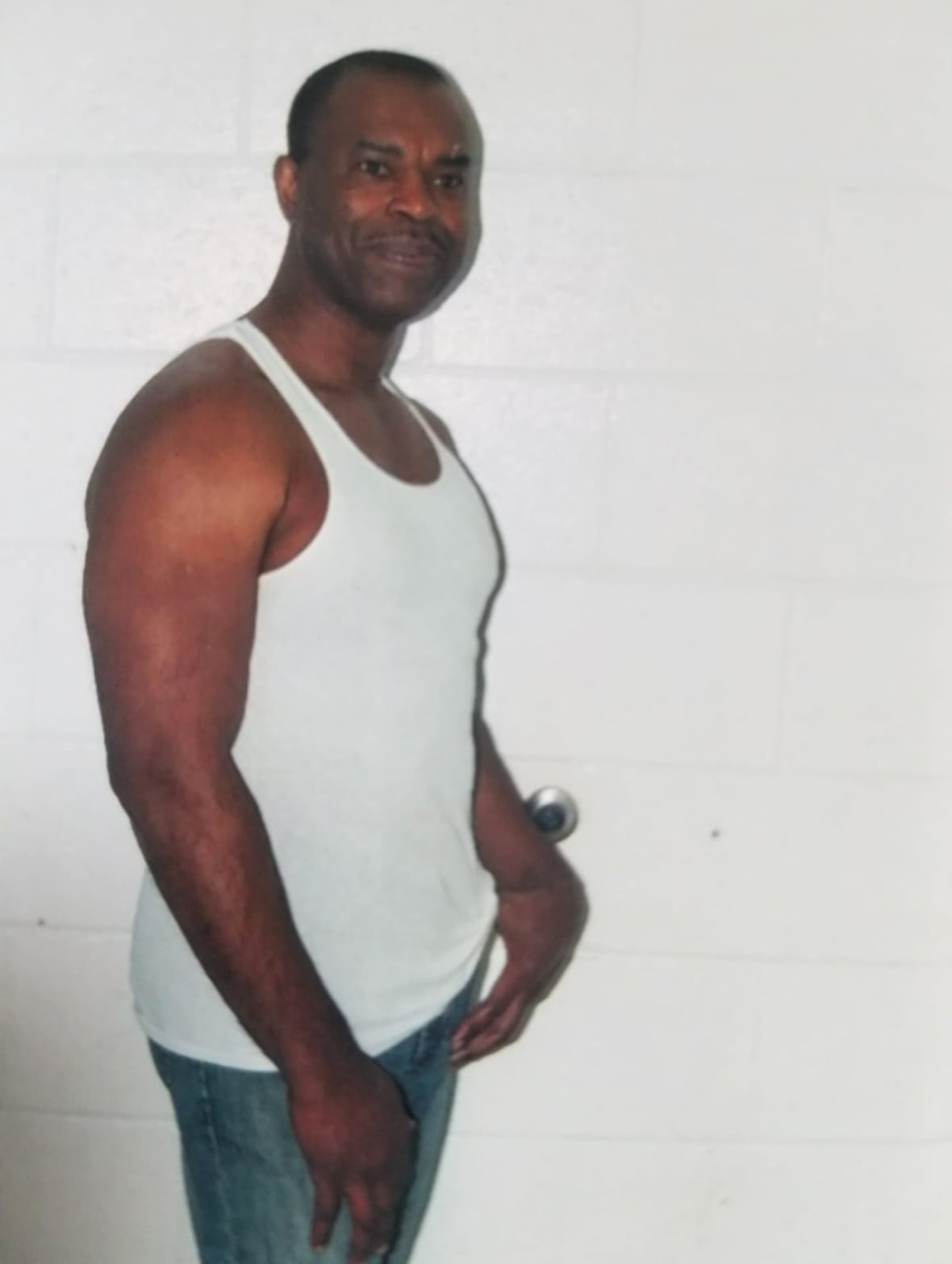 A black man in a white undershirt.